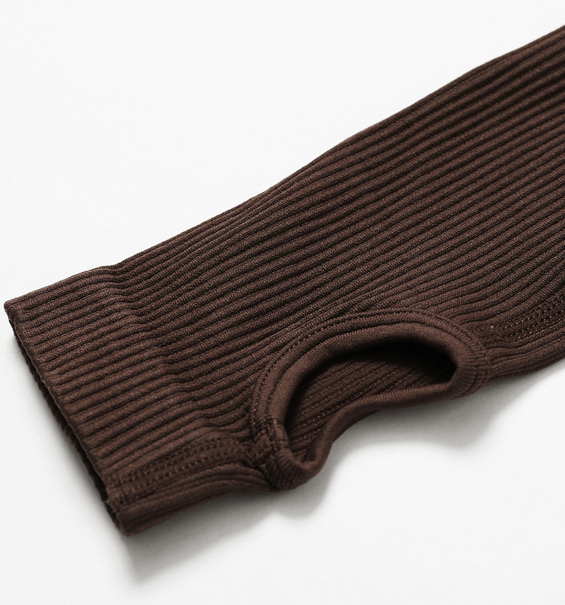 Close-up of brown seamless yoga suit sleeve with thumb hole, featuring ribbed texture for women's fitness and athleisure.